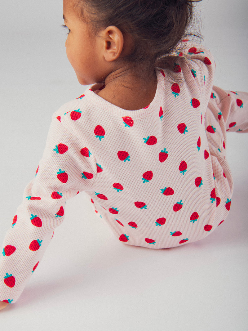 Mameluco rosa con impresión integral de fresas para bebé niña