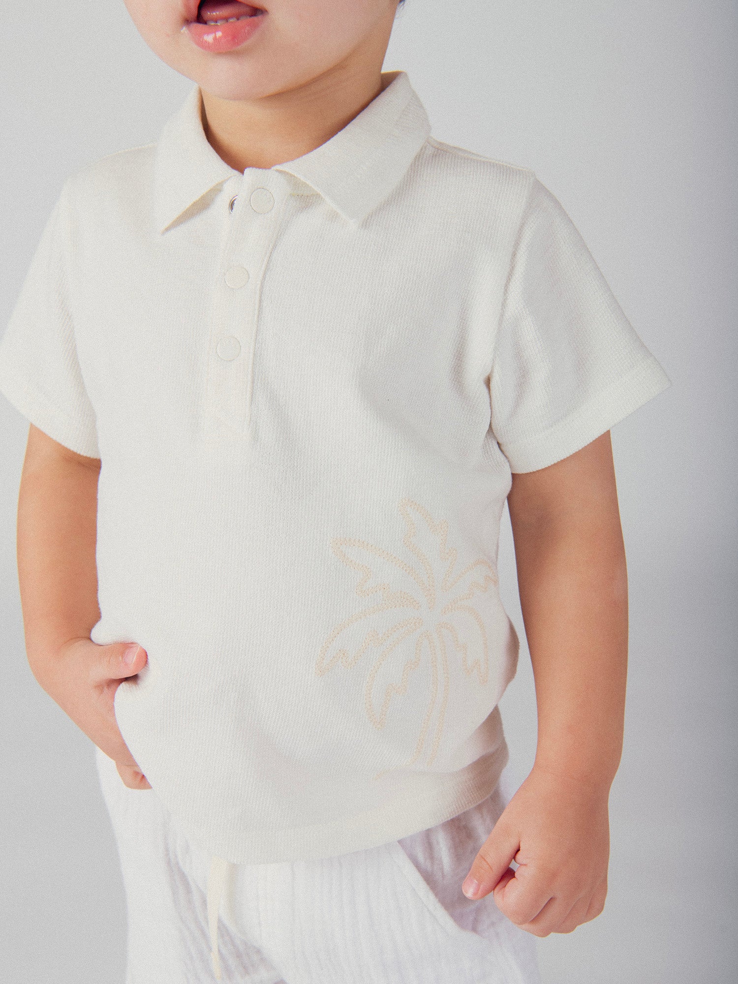 Polo ecru con bordado de palma para bebé niño