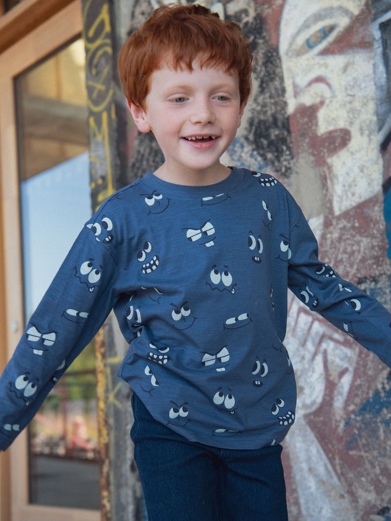 Camiseta azul de manga larga con estampado de ojos fosforescentes para niño