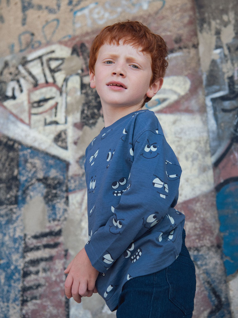 Camiseta azul de manga larga con estampado de ojos fosforescentes para niño