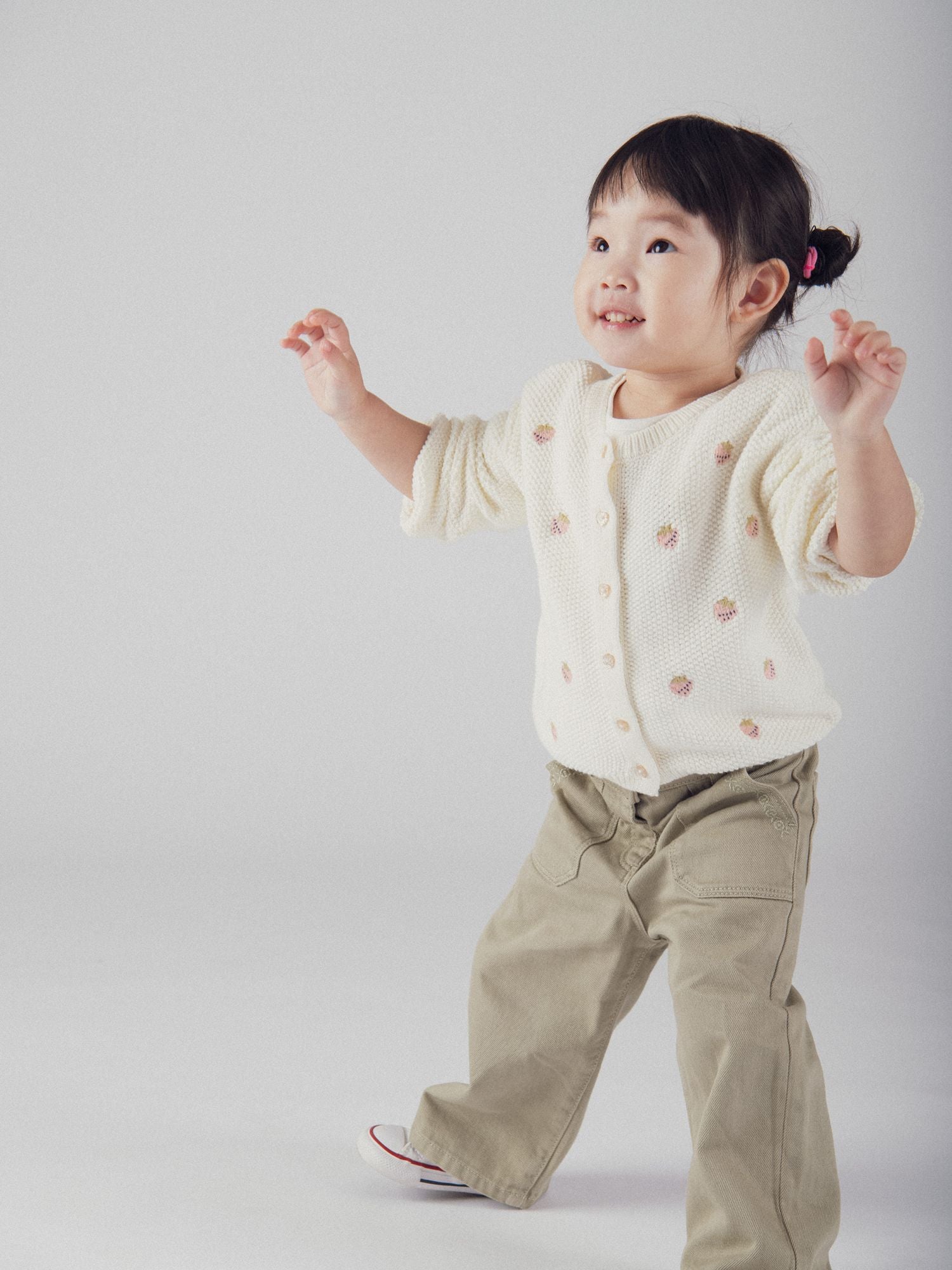 Cárdigan de punto ecru con brodería de fresa para bebé niña