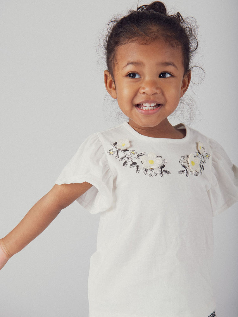 Camiseta ecru bordada con flores y mangas con volantes para niña